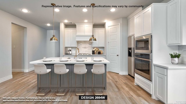 kitchen featuring white cabinetry, tasteful backsplash, light hardwood / wood-style flooring, oven, and decorative light fixtures