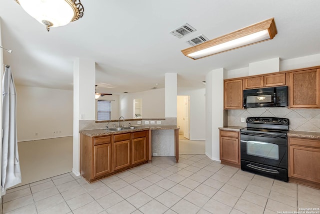 kitchen with light stone countertops, sink, ceiling fan, decorative backsplash, and black appliances