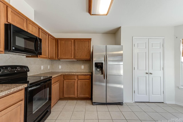 kitchen featuring light stone countertops, decorative backsplash, light tile patterned flooring, and black appliances