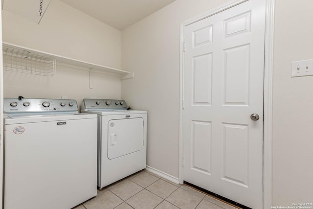 washroom with light tile patterned floors and washing machine and clothes dryer