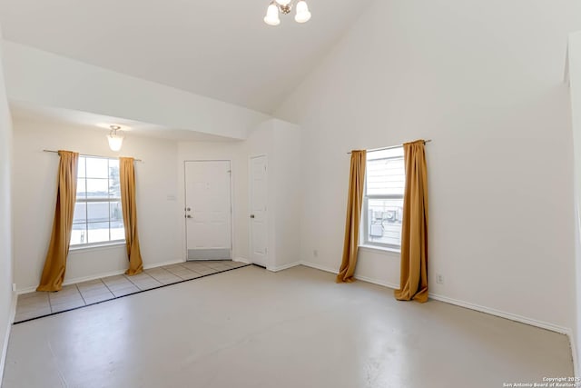 empty room featuring lofted ceiling and a chandelier