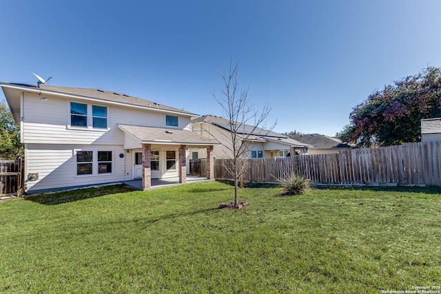 back of property with a patio area and a yard