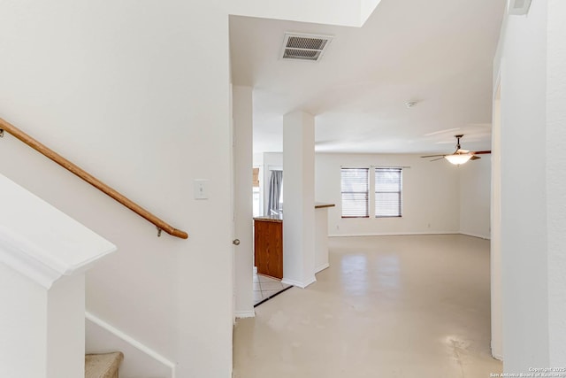 stairs featuring ceiling fan and concrete flooring