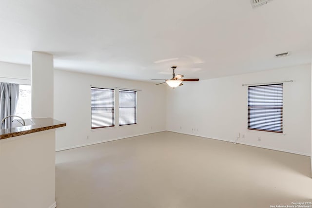 unfurnished living room with ceiling fan