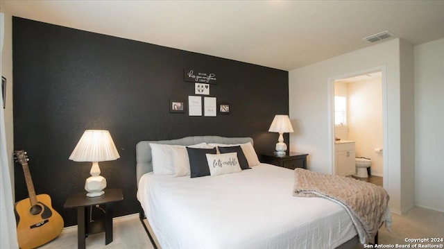 carpeted bedroom featuring ensuite bathroom