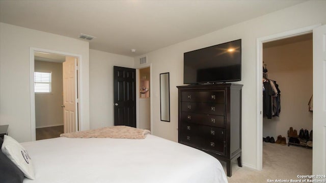 carpeted bedroom featuring a spacious closet and a closet