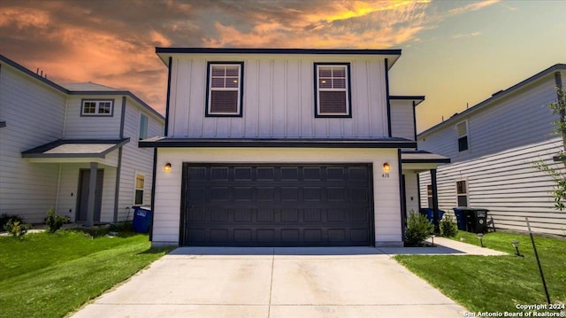 front facade featuring a garage and a yard