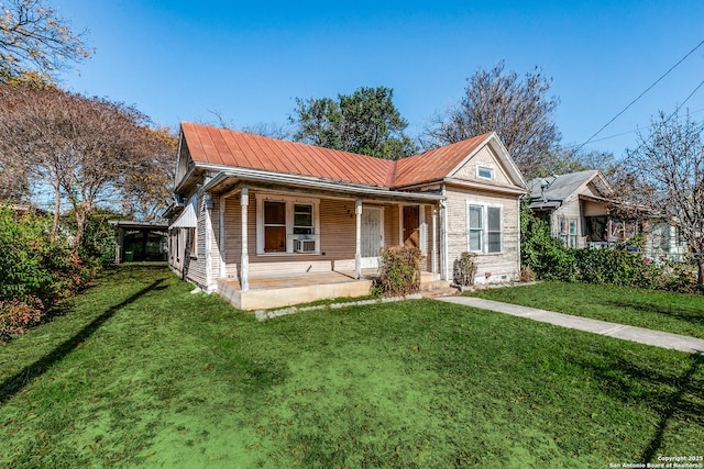 single story home with cooling unit, covered porch, and a front yard