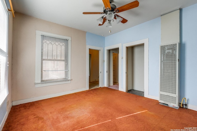 unfurnished bedroom featuring carpet, multiple windows, and ceiling fan