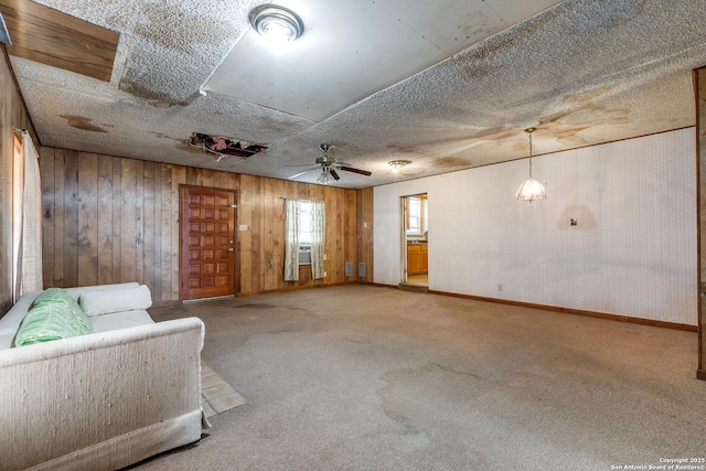 unfurnished room featuring ceiling fan, carpet floors, and wooden walls