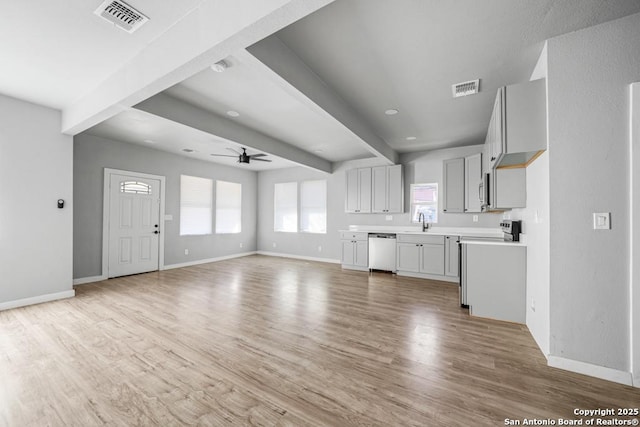 kitchen featuring ceiling fan, light hardwood / wood-style flooring, beamed ceiling, gray cabinets, and dishwashing machine