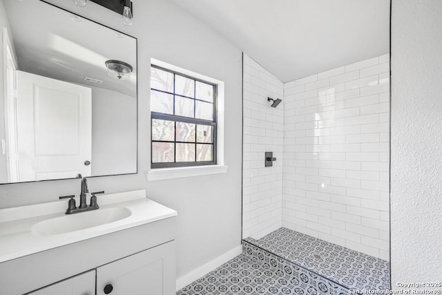 bathroom with vanity and a tile shower