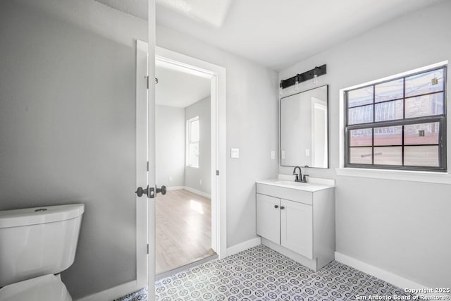 bathroom featuring plenty of natural light, toilet, and vanity