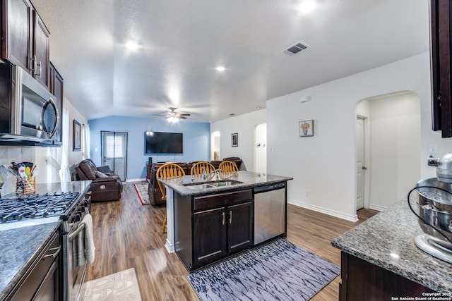 kitchen with dark brown cabinets, a center island, stainless steel appliances, and dark hardwood / wood-style floors