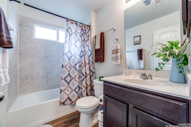 full bathroom with shower / tub combo, vanity, hardwood / wood-style flooring, and toilet