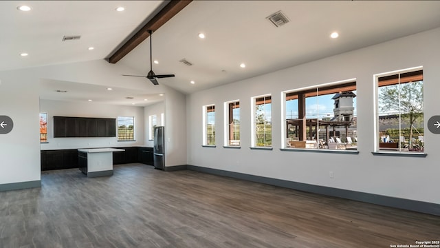 unfurnished living room featuring a wealth of natural light, lofted ceiling with beams, ceiling fan, and dark wood-type flooring