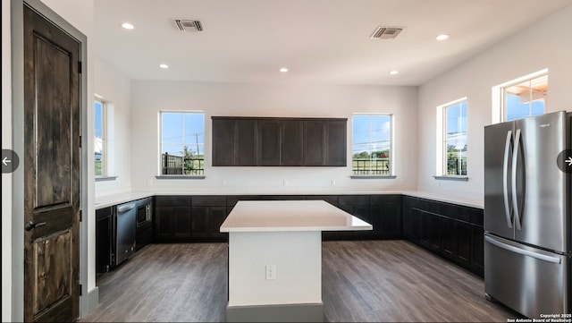 kitchen with a wealth of natural light, a center island, dark hardwood / wood-style flooring, and appliances with stainless steel finishes