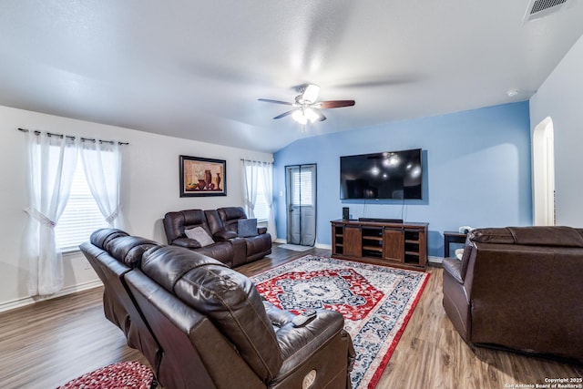 living room with light wood-type flooring, vaulted ceiling, and ceiling fan