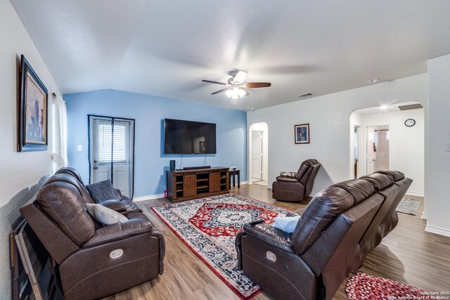 living room with ceiling fan, hardwood / wood-style floors, and vaulted ceiling