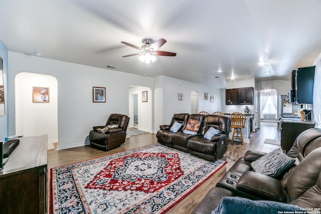 living room featuring ceiling fan, hardwood / wood-style floors, and vaulted ceiling