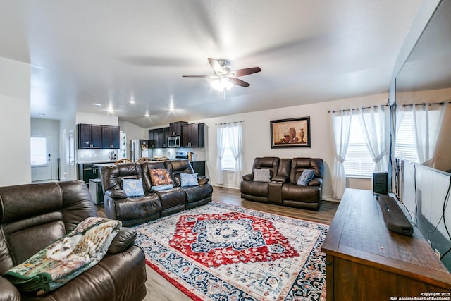 living room with ceiling fan, light hardwood / wood-style flooring, and lofted ceiling