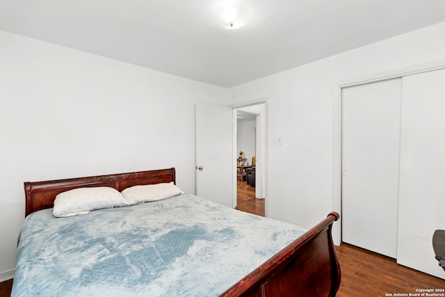 bedroom with a closet and dark wood-type flooring