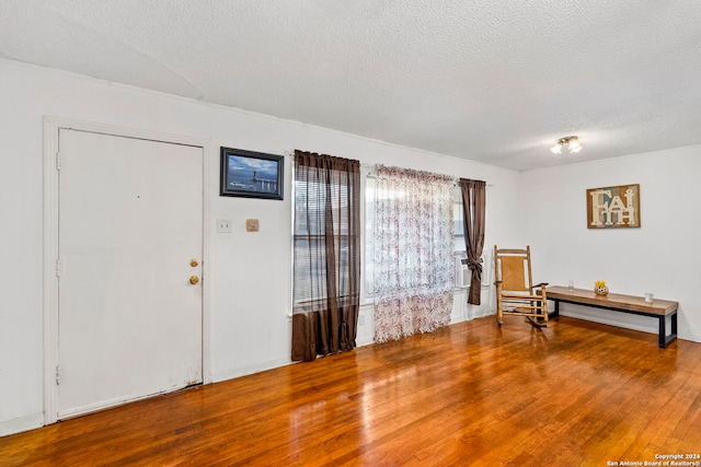 foyer entrance featuring a textured ceiling and hardwood / wood-style flooring