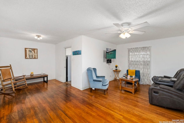 living room featuring ceiling fan, wood-type flooring, and a textured ceiling