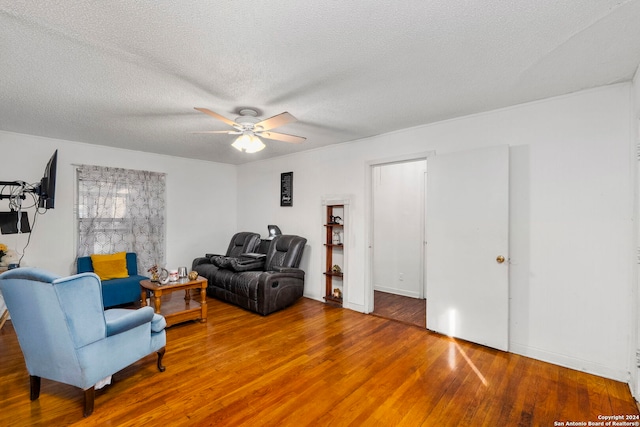 sitting room with hardwood / wood-style floors, ceiling fan, and a textured ceiling