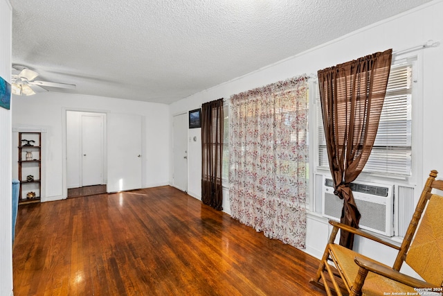 empty room with dark hardwood / wood-style floors, ceiling fan, a textured ceiling, and cooling unit