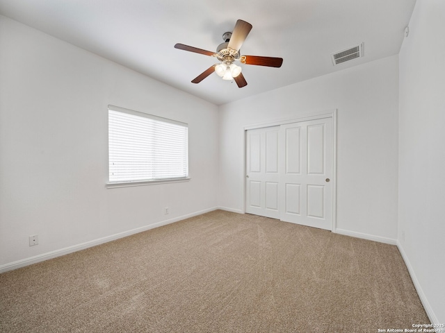 unfurnished bedroom featuring a closet, carpet flooring, visible vents, and baseboards