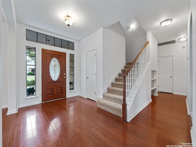 entrance foyer featuring baseboards, stairway, and wood finished floors