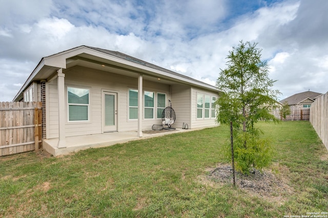 rear view of house with a lawn and a patio