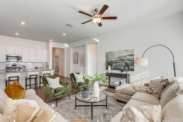 living room featuring ceiling fan, light wood-type flooring, and sink