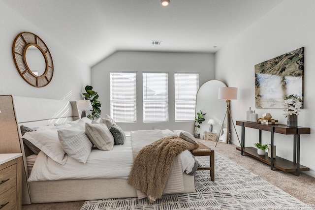 bedroom featuring light colored carpet and vaulted ceiling