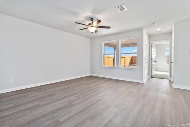 spare room featuring a textured ceiling, hardwood / wood-style flooring, and ceiling fan