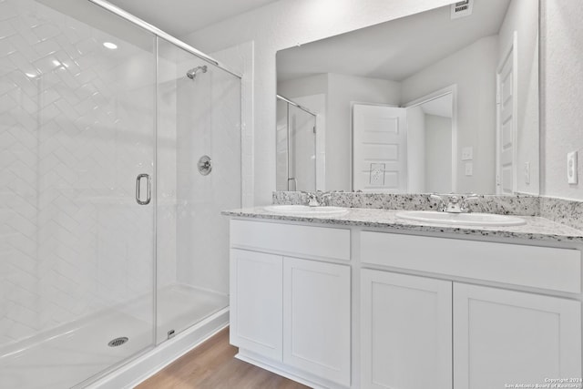 bathroom featuring wood-type flooring, vanity, and walk in shower