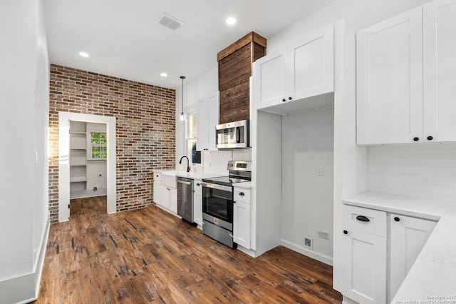 kitchen with white cabinetry, hanging light fixtures, and stainless steel appliances