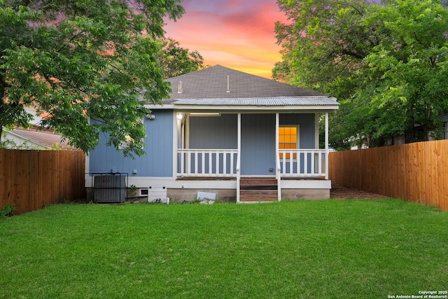 view of front of property with a lawn, central AC unit, and a porch