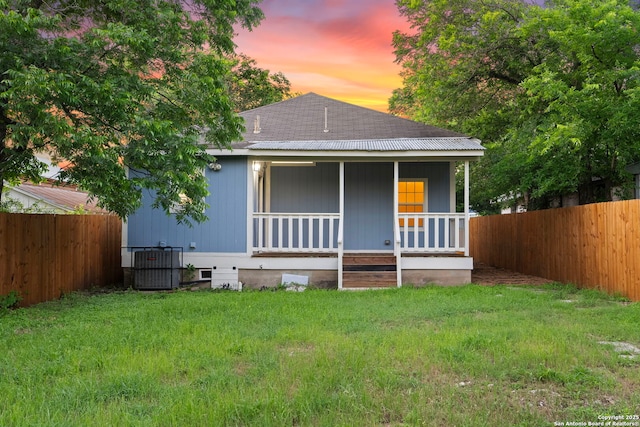 bungalow with a yard, cooling unit, and covered porch