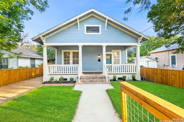 bungalow featuring covered porch and a front lawn