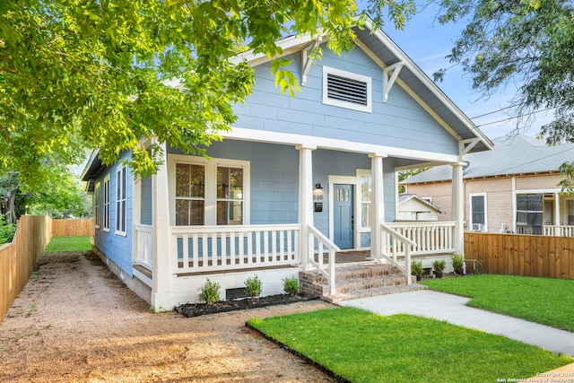 bungalow-style house featuring covered porch and a front yard