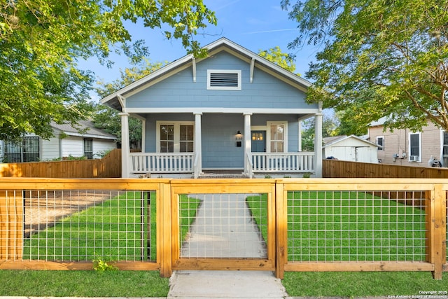 bungalow with covered porch and a front yard