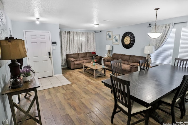 dining space featuring light hardwood / wood-style flooring and a textured ceiling