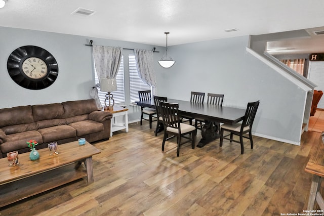 dining space with wood-type flooring