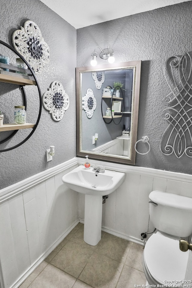 bathroom with tile patterned flooring, toilet, and sink