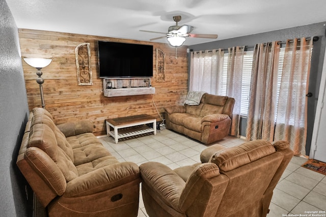 tiled living room featuring ceiling fan and wooden walls