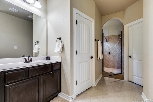 bathroom with tile patterned flooring, vanity, and a shower with shower door