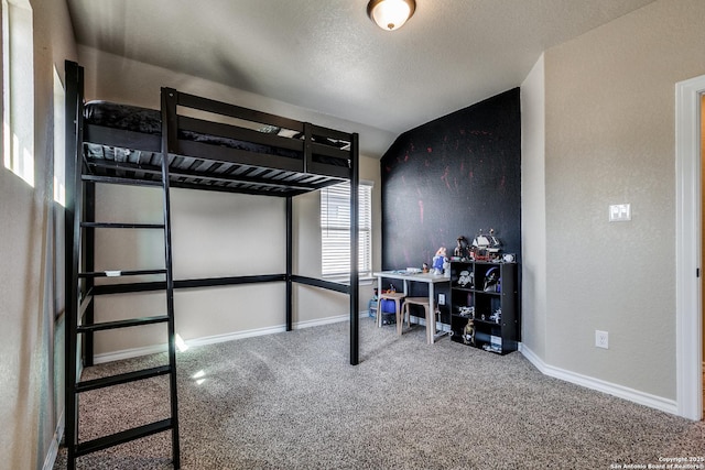 bedroom featuring a textured ceiling, carpet, and lofted ceiling