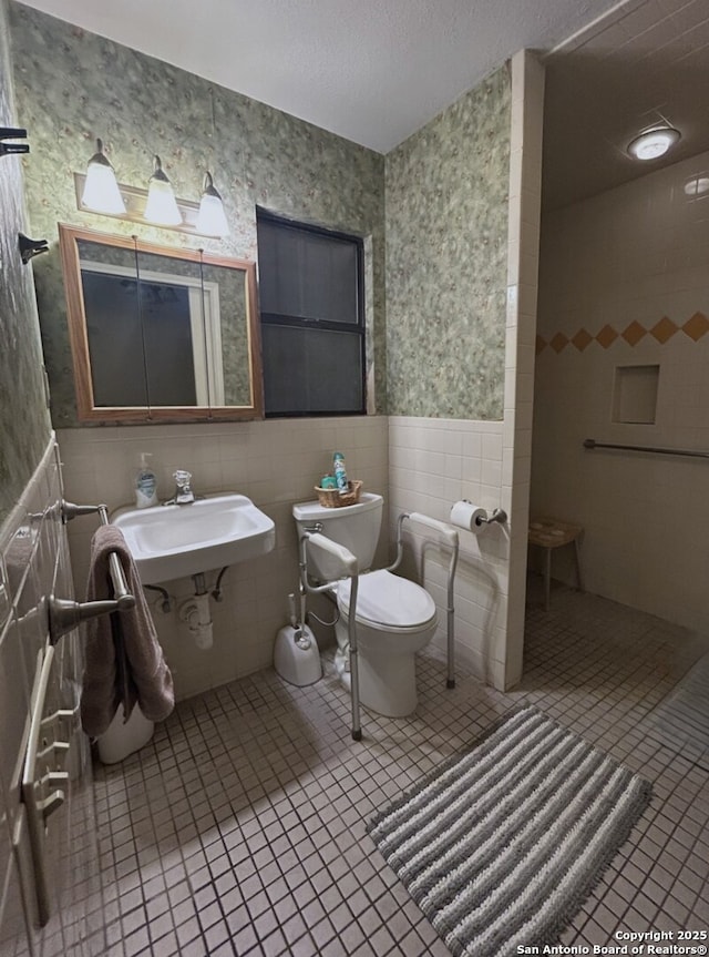 bathroom with sink, tile walls, toilet, and tile patterned flooring